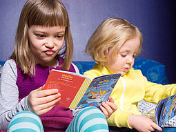 Ein Mädchen und ein Bub lesen Hollis Minibuch