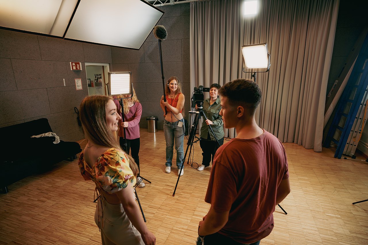 MZ_23_KRENN_v1-139 Eine Gruppe an Jugendlichen dreht einen Film in einem Studio.