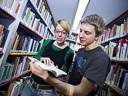 Zwei junge Menschen in einer Bibliothek