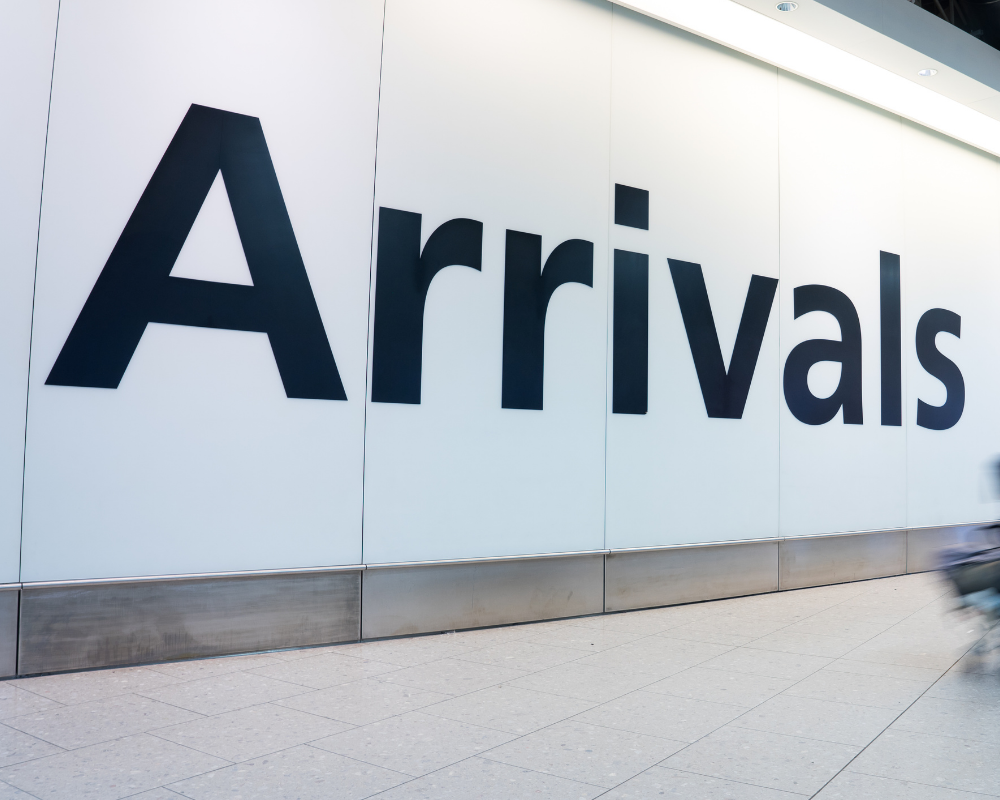 An einer Wand steht "Arrivals"