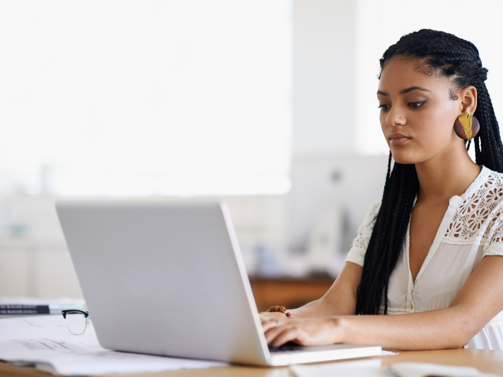 eine Person sitzt vor einem Laptop und schreibt eine Bewerbung