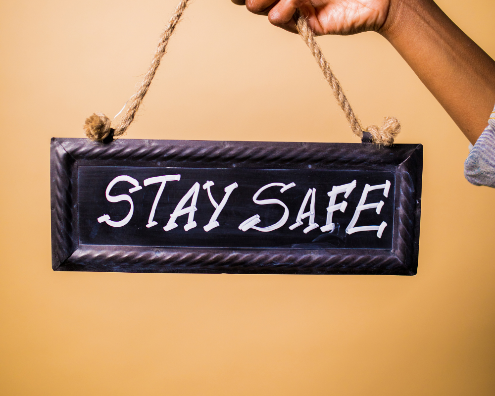 Eine Person hält ein Schild auf dem "Stay safe" steht
