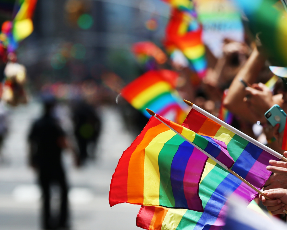 mehrere Regenbogenflaggen auf einer Demo