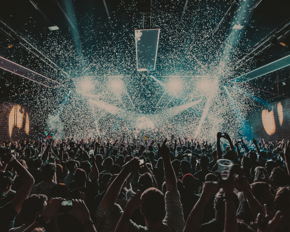 ein Club mit vielen Menschen mit türkis blauen Diskolichtern