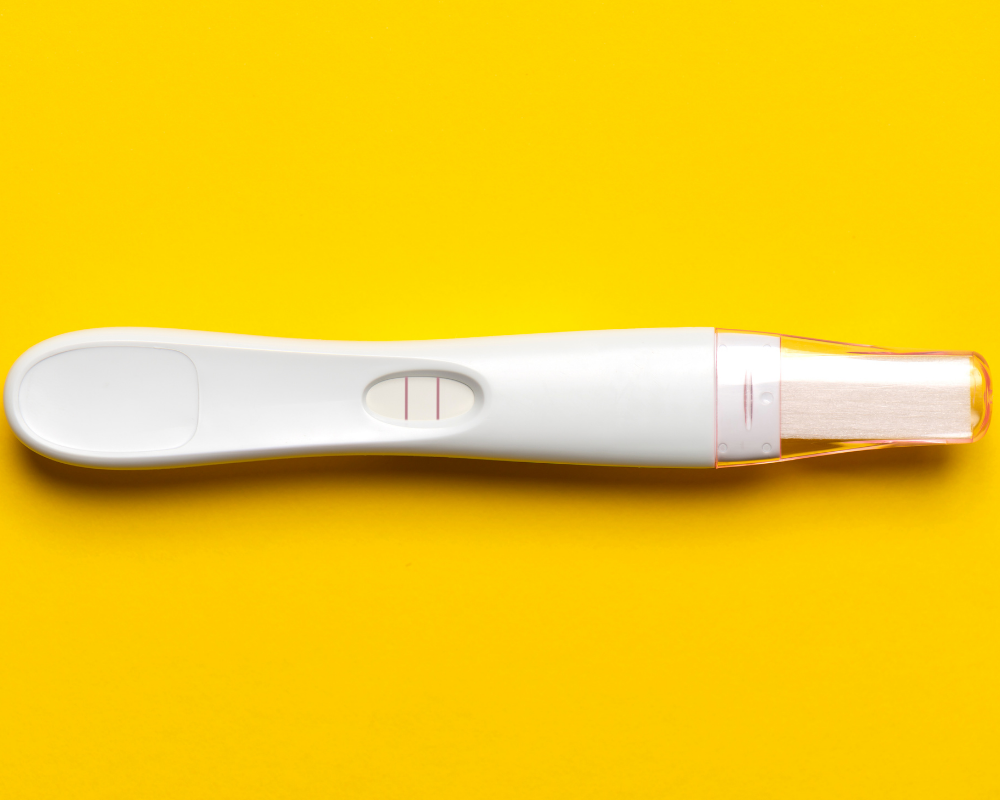 Schwangerschaftstest vor gelben Hintergrund