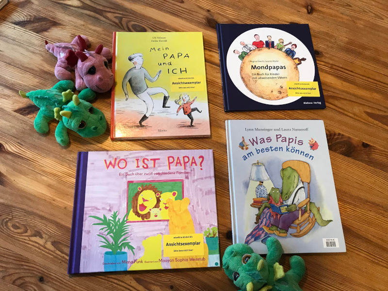 Bücher Drei Plüschdrachen und Büchercover von Mein Papa und ich von Ulf Nilsson und Heike Herold, Mondpapas von Regina Deertz und Leonie Rösler, Wo ist Papa? von Mirna Funk und Maayan Sophia Weisstub sowie Was Papis am besten können von Lynn Munsinger und Laura Numeroff.