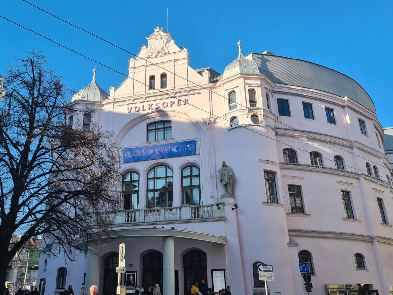 Volksoper Wien Volksoper von Außen, blauer Himmel und ein Baum steht vor dem Haus