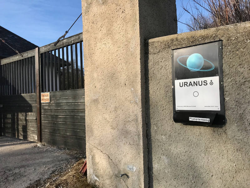 Bild von Uranus Tafel mit Bild von Uranus und Beschreibungstext auf einem Torbogen im Lainzer Tiergarten