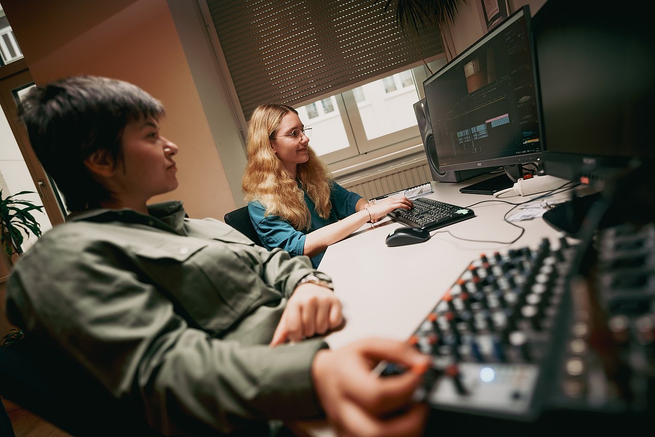 MZ_23_KRENN_v1-206 zwei Frauen sitzen vor einem Computer, auf dem ein Videoschnittprogramm geöffnet ist