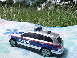 Polizeispielzeugauto auf einer Picknickdecke