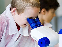 Forschen Entdecken und Experimente 15 Kind schaut durch Mikroskop