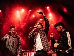 Soundbase Drei junge Musiker feiern ihren ersten Live-Auftritt auf der Bühne.