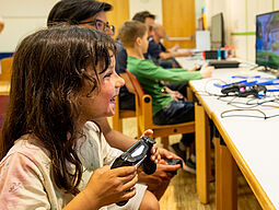 Kind_PS4_Controller Zu sehen ist ein lachendes Kind mit einem Controller in der Hand.