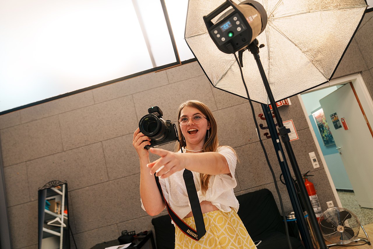 mz2025 x ste.krenn-110 Eine Jugendliche lacht, während sie in einem Studio fotografiert.