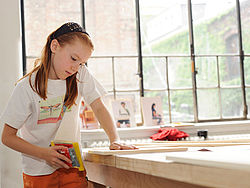 Bauen Maedchen schleift an Brettern zum Bauen