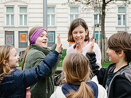 Junges Wien Eine Gruppe von Kindern gibt sich gut gelaunt ein High-Five!