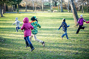 Kindergruppe spielt auf einer Lichtung