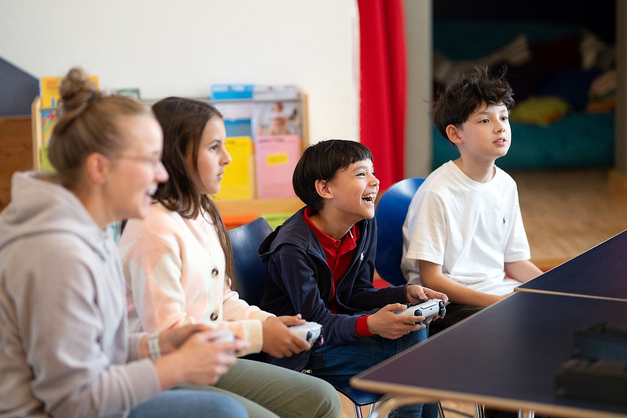 8315_© Barbara Mair Kopie Kinder und Erwachsene spielen an Konsole