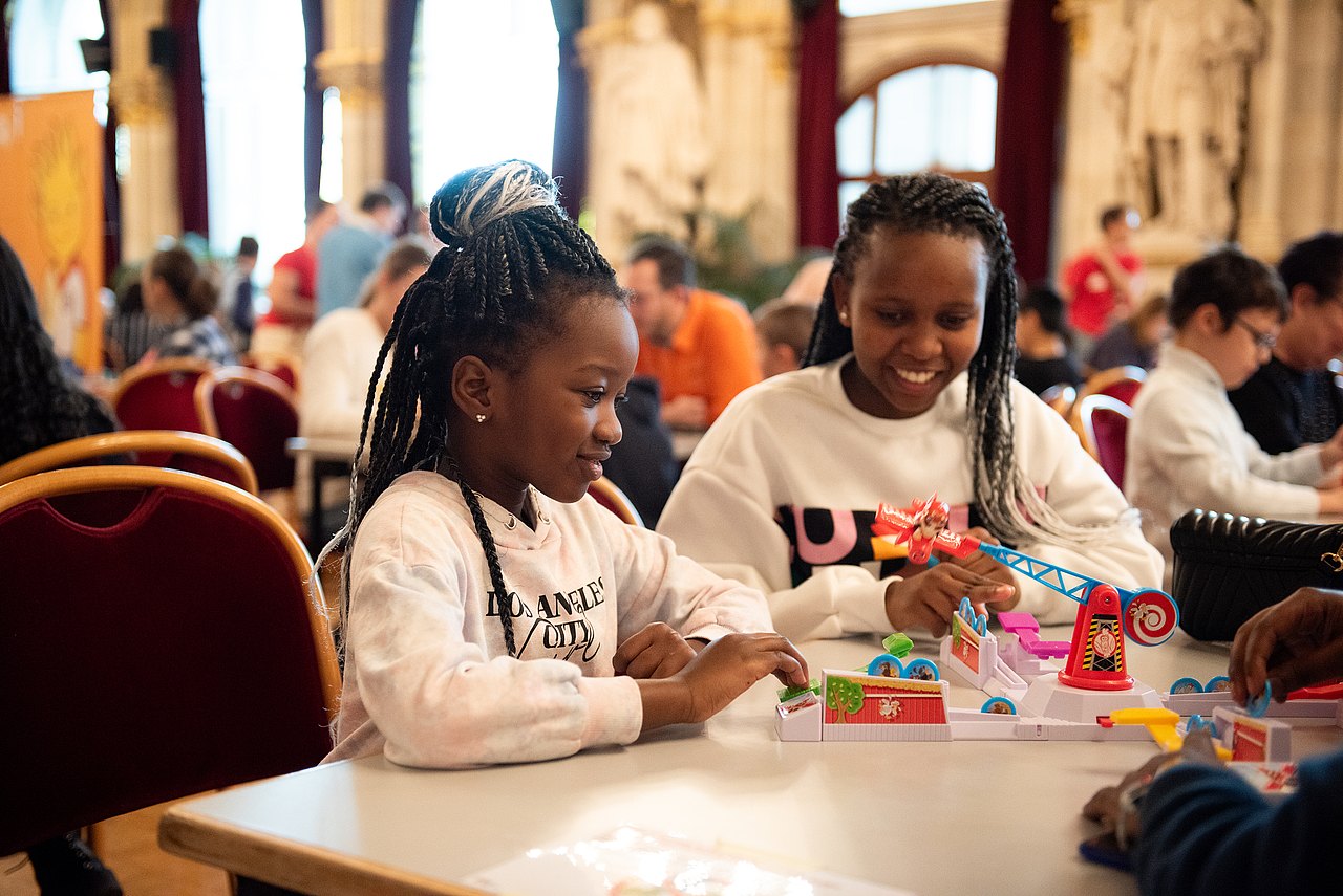 Spielebox - Spieltage im Rathaus 2 Kinder an einem Tisch spielen ein Brettspiel
