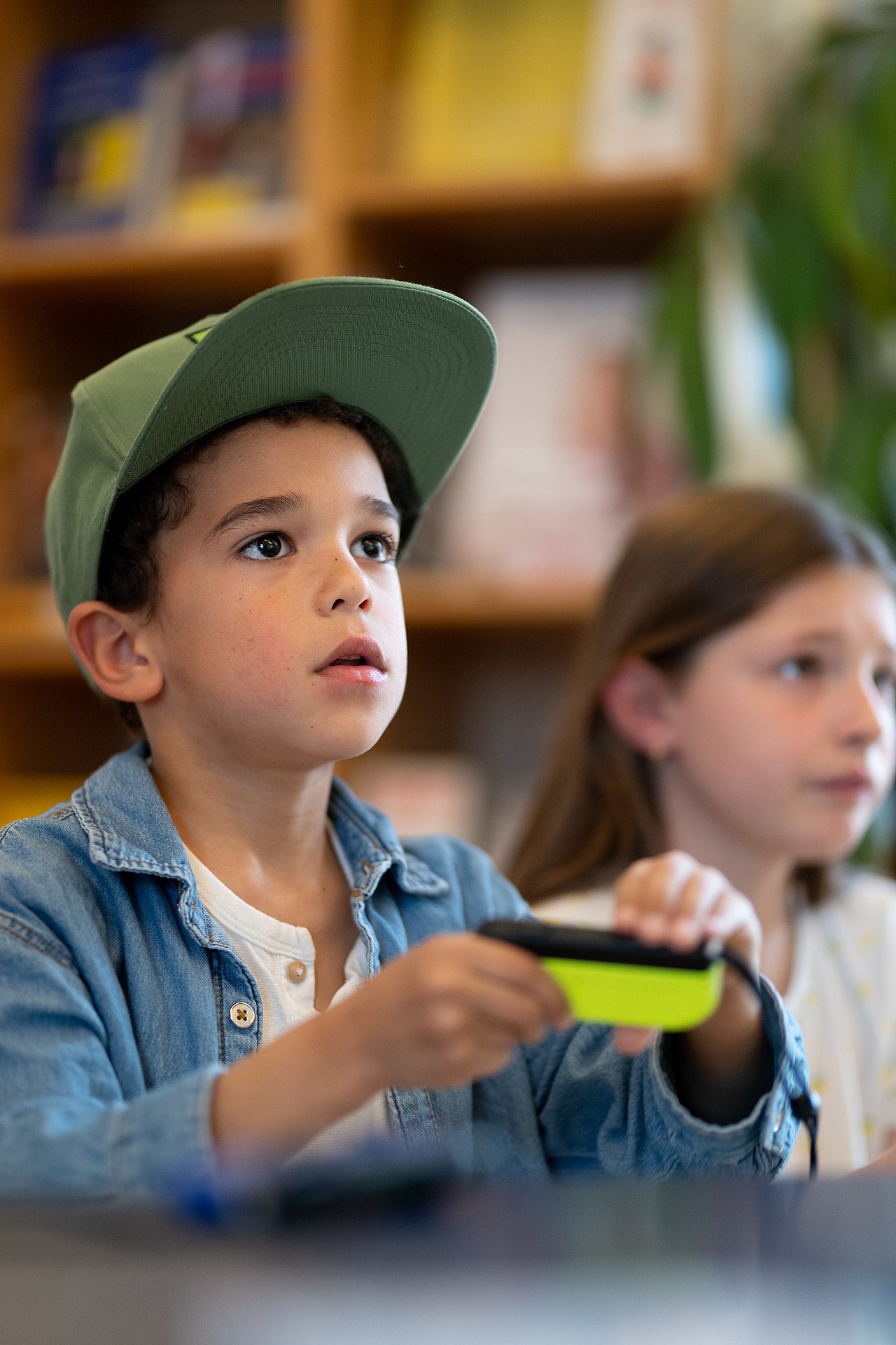 8374_© Barbara Mair Kopie Kind mit Controller in der Hand schaut konzentriert auf den TV