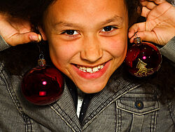 Mädchen mit Christbaumkugeln als Ohrringe Mädchen mit Christbaumkugeln als Ohrringe