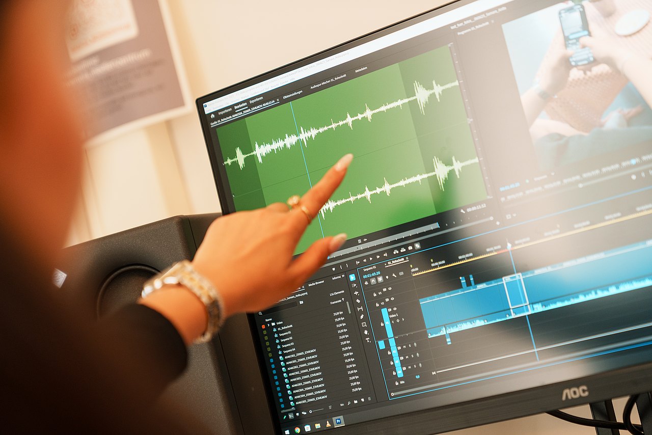 mz2025 x ste.krenn-150 Eine Jugendliche zeigt auf einen Monitor, auf dem eine Tonspur geöffnet ist.
