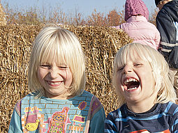 Strohfreude Kinder auf einer Strohpyramide