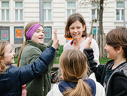 Kindergruppe in der Stadt - klatscht ab