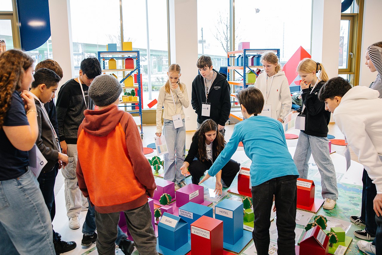 251204_R3_0834 Jugendliche auf Stadtplan diskutieren über Stadtgestaltung