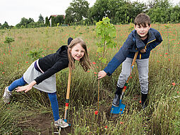 2 Kinder mit Schaufel im Wald