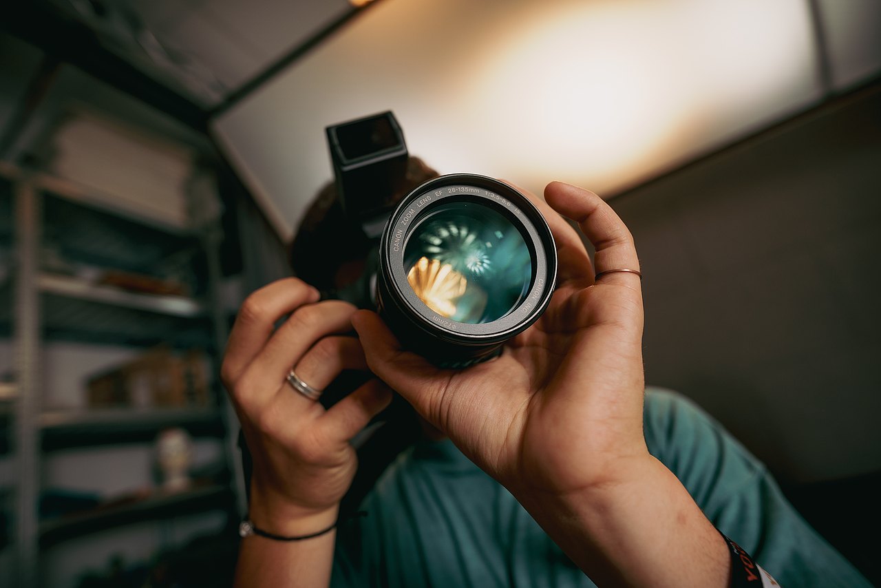 MZ_23_KRENN_v1-107 Ein Jugendlicher fotografiert mit einer professionellen Fotokamera in einem Studio.