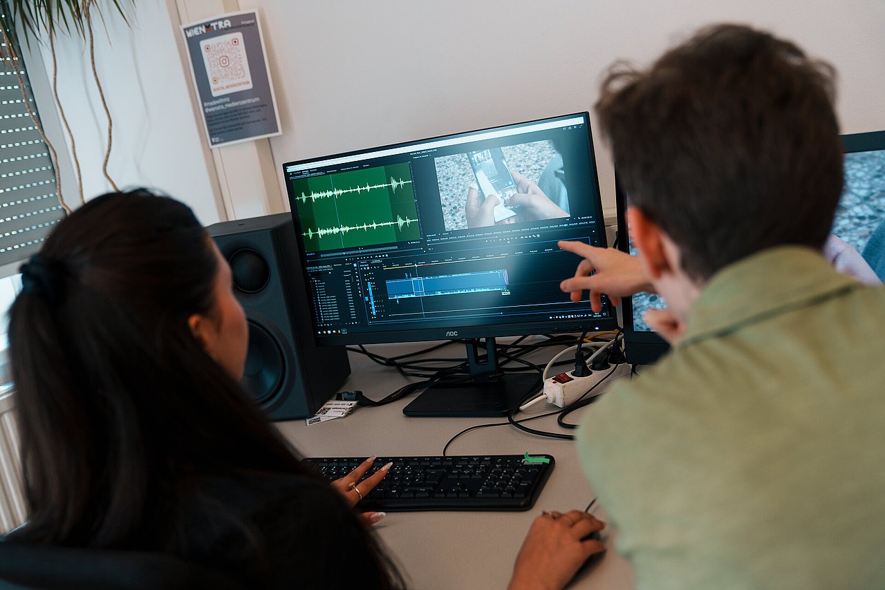 mz2025 x ste.krenn-144 Zwei Jugendliche schneiden einen Film auf einem Computer-Monitor.