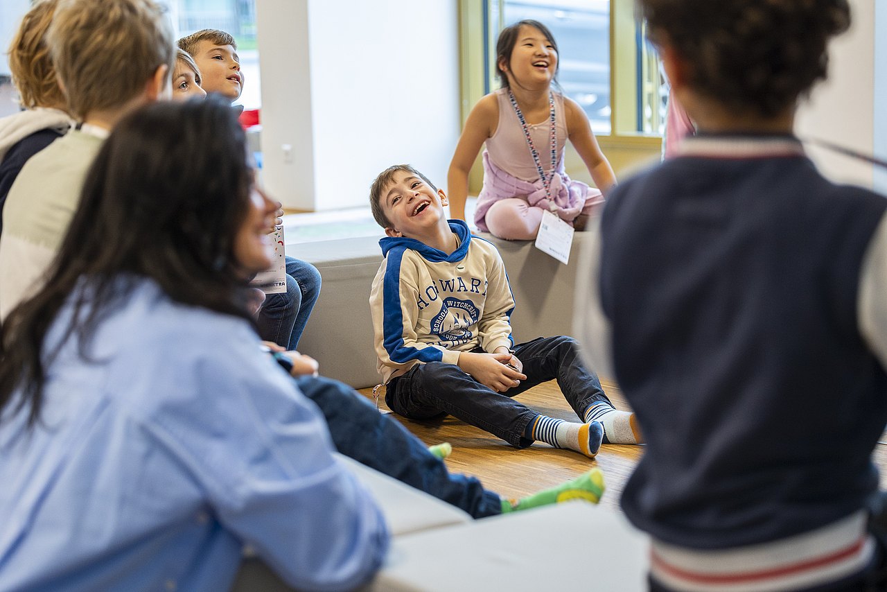 221117_2-25 Kinder sitzen in Sitzkreis und lachen
