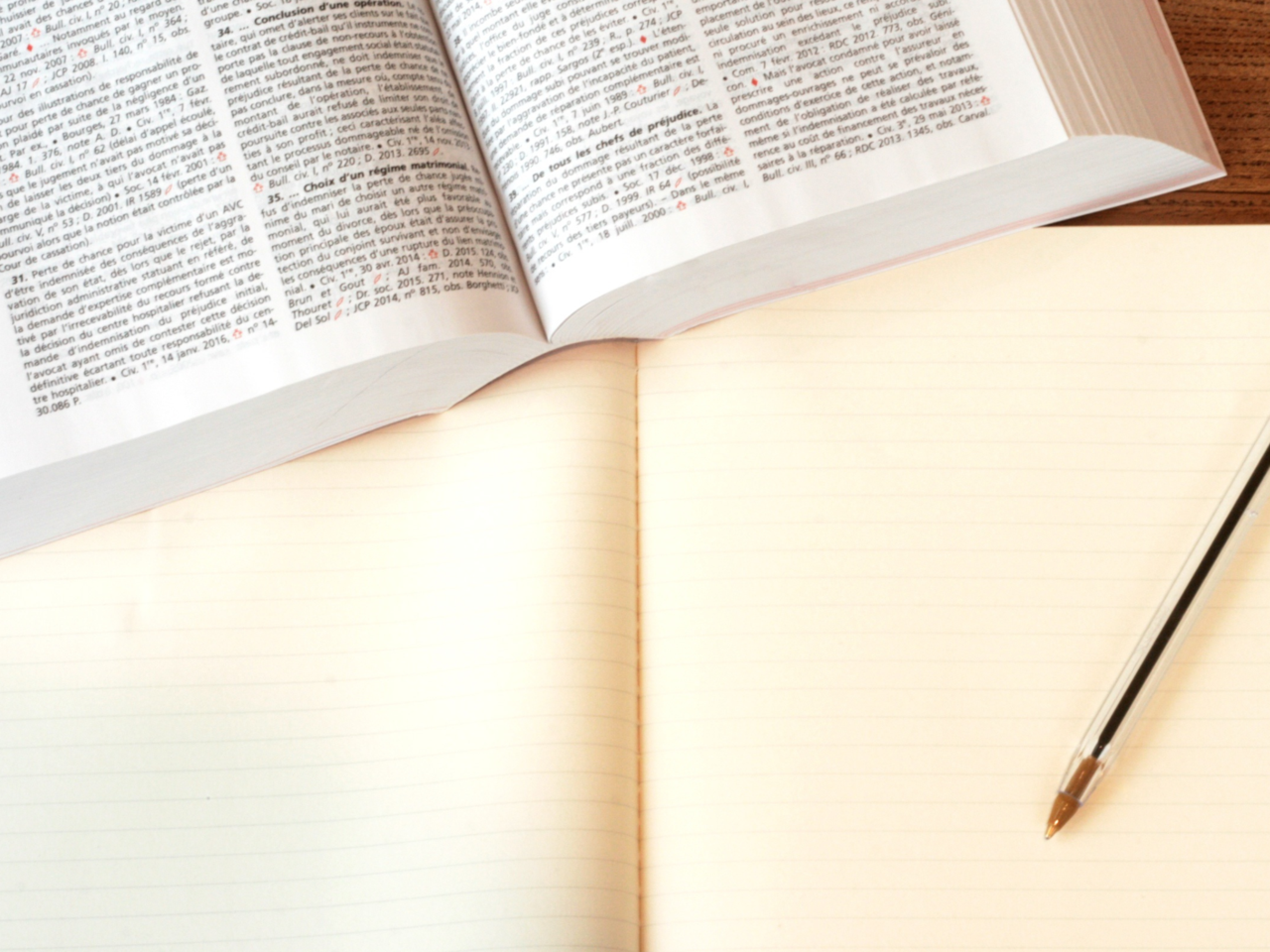 Ein Buch über Rechtsinfos liegt vor einem Notizbuch inklusive Stift