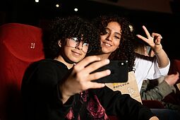 Jugendliche machen ein Selfie im Kino