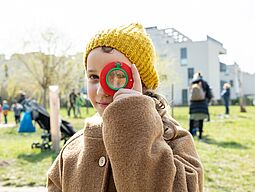Herbst Ein Mädchen schaut durch eine Lupe.