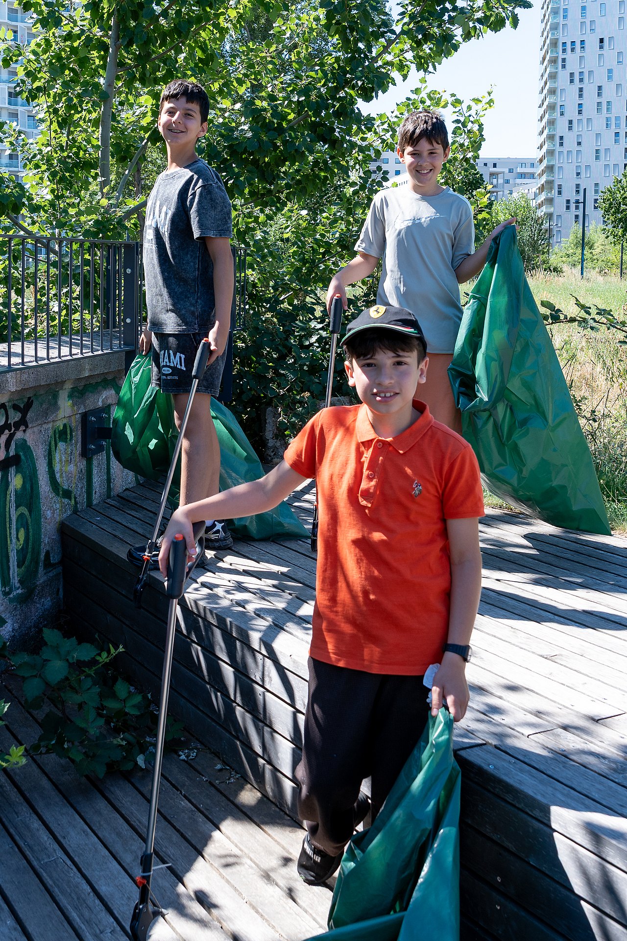 EAW_c_Kajetan_Koren_24062026_013 Zu sehen sind drei Schüler mit Müllsäcken und Greifzangen.