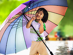 Kind mit Regenbogenschirm