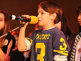 Bub spricht in eine Mikro