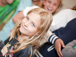 Laechelndes Maedchen im Hintergrund eine Kindergruppe