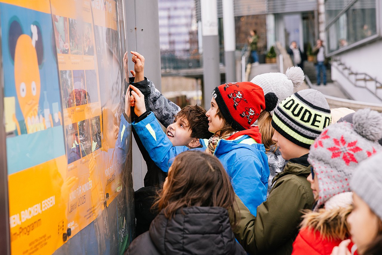 Kinder betrachten Filmplakate Kinder betrachten Filmplakate