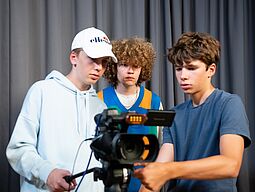 Drei Jugendliche drehen einen Film.
