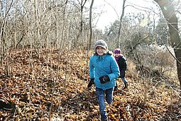 Zwei Kinder laufen durch den Winterwald.