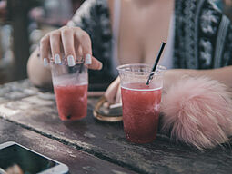 Frau an Bar mit zwei Drinks vor sich