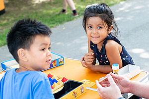Kinder spielen ein Brettspiel im Park