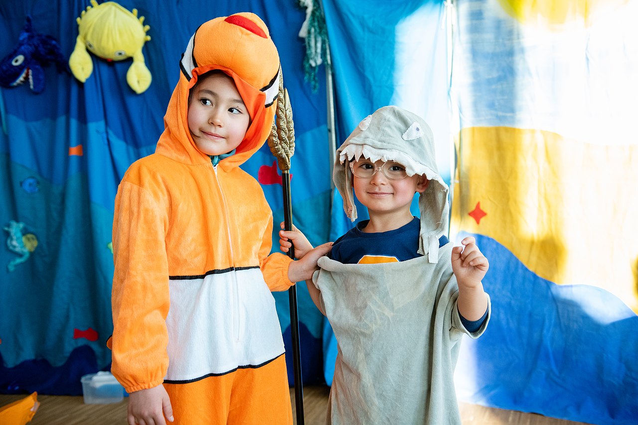 Mitmachtheater_Seestadt_c_Liebentritt_065 Kinder verkleidet als Fische vor blauem Hintergrund