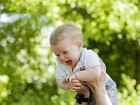 Lachendes Baby im Grünen