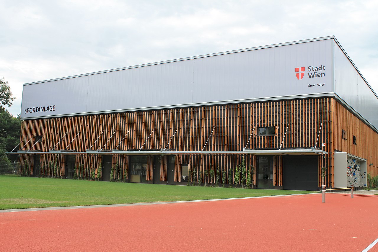 Sicht von außen auf Sporthalle mit Holzfassade