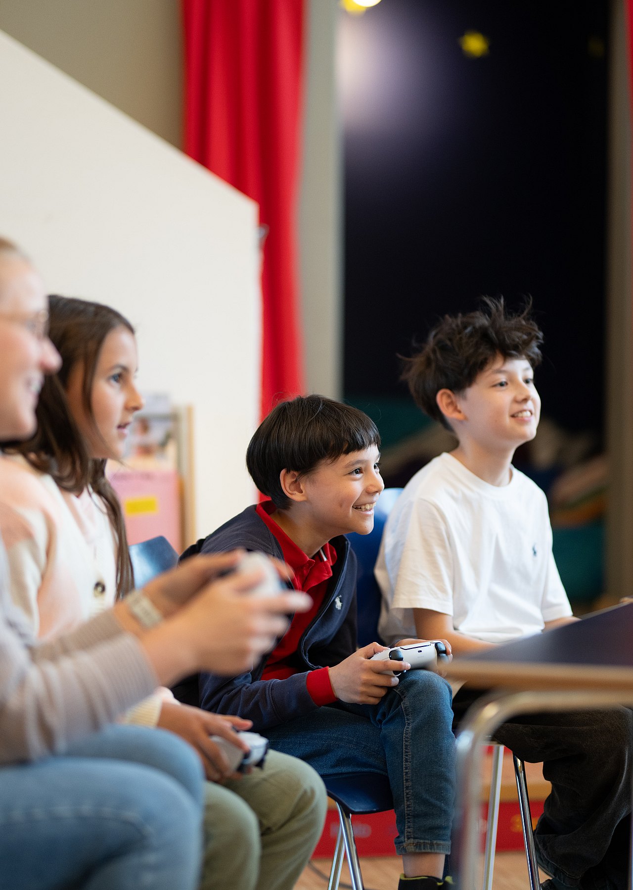 8351_© Barbara Mair Kopie Erwachsene und Kinder spielen lachend an einer Konsole