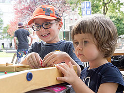 Zwei Kinder mit Brettspiel im Park